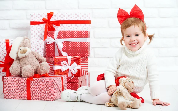 Mutlu küçük kız çocuk Noel hediyeleri duvar ile — Stok fotoğraf