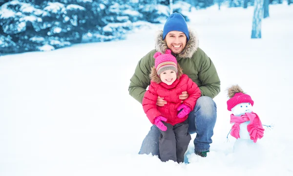 Família feliz pai e criança menina faz boneco de neve no inverno — Fotografia de Stock