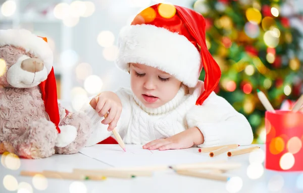 Ребенок перед Рождеством пишет письмо Санте — стоковое фото