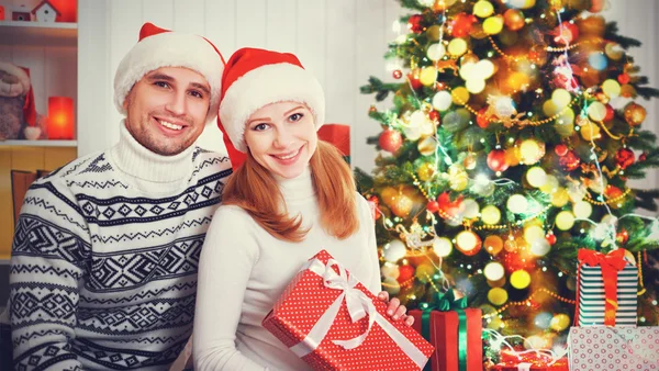 Feliz casal familiar com um presente no Natal em casa — Fotografia de Stock
