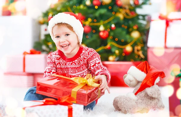 Ευτυχισμένο παιδί με Χριστουγεννιάτικα δώρα κοντά ένα χριστουγεννιάτικο δέντρο — Φωτογραφία Αρχείου