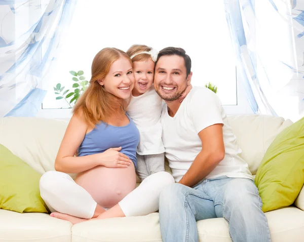 happy family. pregnant mother, father, and child daughter at hom