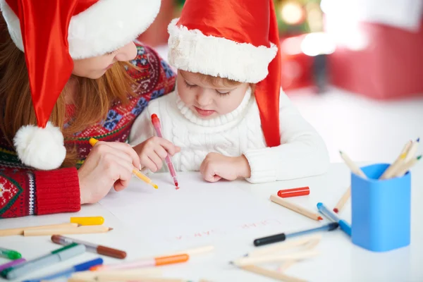 Heureux famille mère et enfant fille écrire aletter à Santa o — Photo