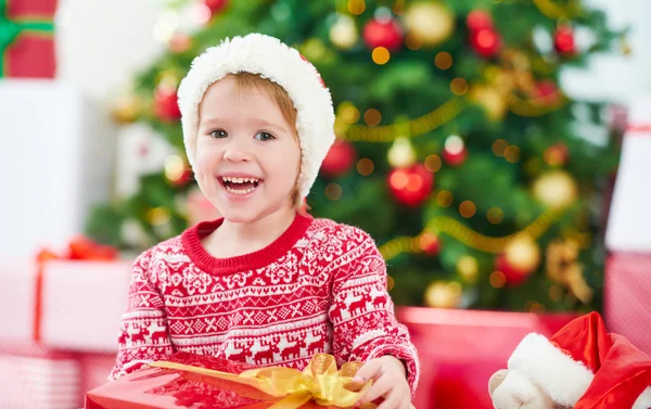 Щаслива дитина з різдвяними подарунками біля ялинки — стокове фото