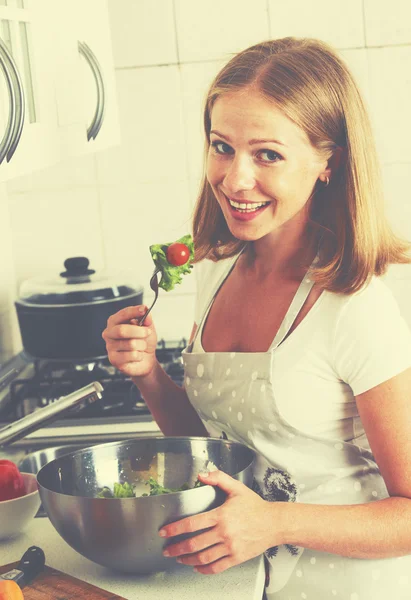 Mulher feliz dona de casa preparando salada na cozinha — Fotografia de Stock