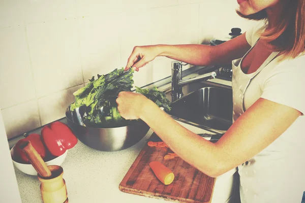 Glückliche Hausfrau bereitet Salat in der Küche zu — Stockfoto