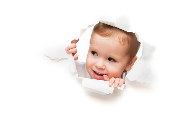 Funny  child baby girl peeping through hole in an empty white  p — Stock Photo, Image