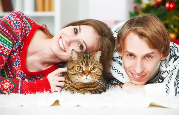 Счастливая семейная пара и кошка на Рождество дома — стоковое фото