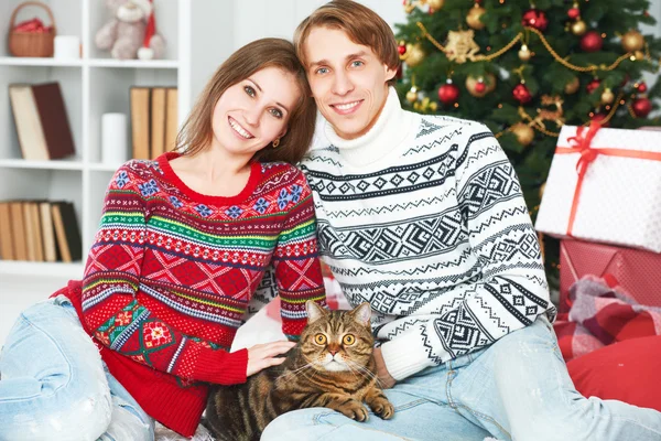 Familia feliz pareja y un gato en Navidad en casa — Foto de Stock