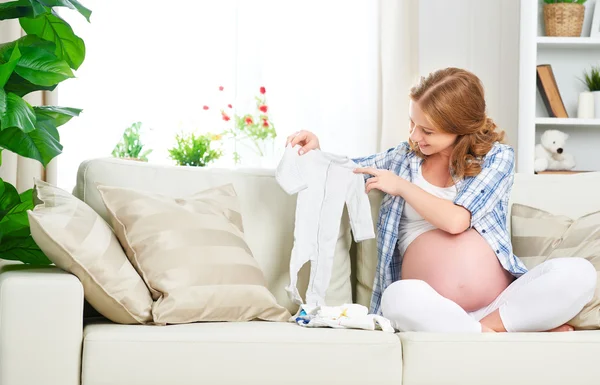 Embarazada mujer embarazada madre prepara artículos de ropa para newb — Foto de Stock