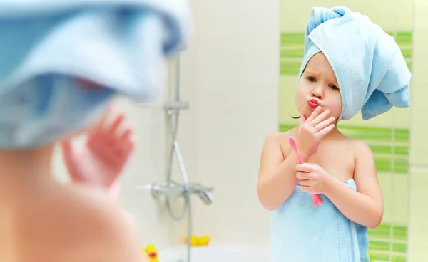 Divertente bambina pulisce i denti con lo spazzolino da denti in bagno — Foto Stock
