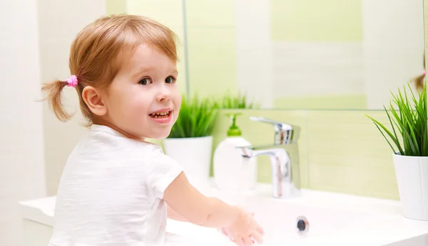 Enfant petite fille se lave les mains dans la salle de bain — Photo