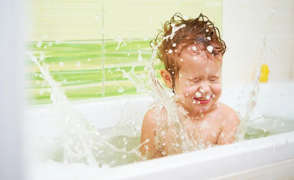 Щаслива дитина купається в ванні і грає з f — стокове фото