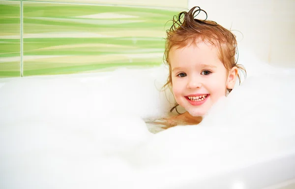 Heureux enfant fille bains dans le bain avec de la mousse et des bulles — Photo