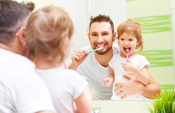 Glad familj far och barn flicka borsta hennes tänder i badrum — Stockfoto