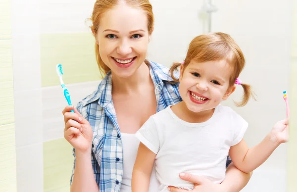 Happy family mother and daughter child brushing her teeth toothb — Stock Photo, Image