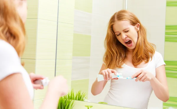 Donna assonnata lavarsi i denti con uno spazzolino da denti al mattino — Foto Stock