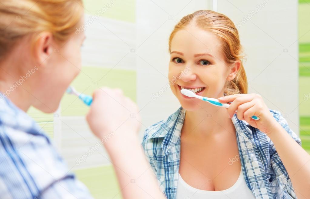 happy woman brushing her teeth with a toothbrush