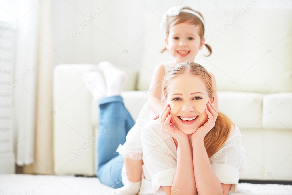 Happy loving family. mother and child playing lying on the floor