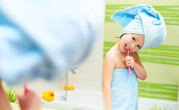 Vicces kis lány tisztítja a fogakat, a fürdőszobában fogkefe — Stock Fotó