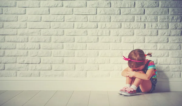 Kind meisje huilen en verdrietig over bakstenen muur — Stockfoto