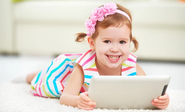 Criança feliz menina brincando no computador tablet — Fotografia de Stock