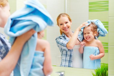 Banyoda mutlu bir aile. havlu kuru saçları olan bir çocuğun annesi