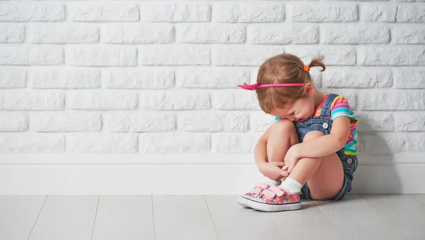 Little child girl crying and sad about brick wall — Stock Photo, Image