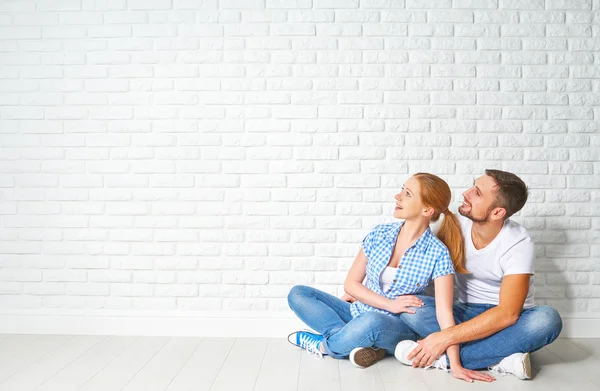 Concept of mortgage housing problems. couple at blank wall — Stock Photo, Image