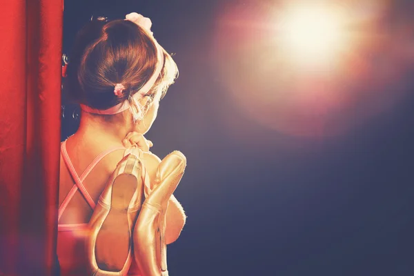 Little girl ballerina ballet dancer on stage in red side scenes — Stock Photo, Image