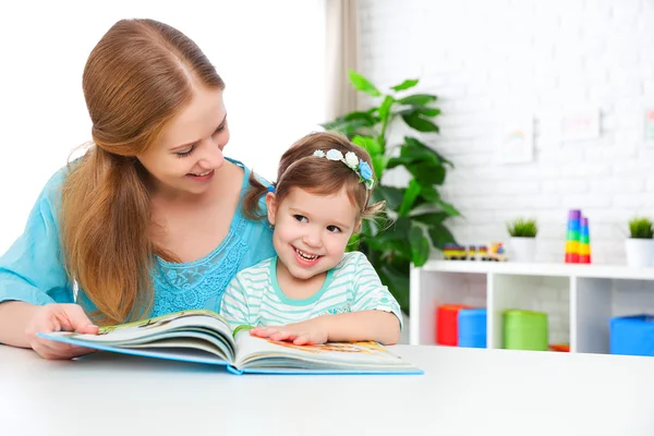 Mamma och barn läser bok hemma — Stockfoto