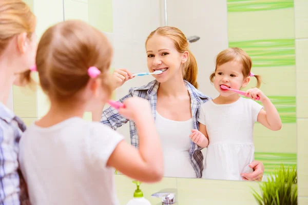 Família feliz mãe e filha criança escovando os dentes denteb — Fotografia de Stock