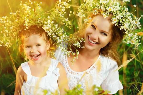 Gelukkig lachen dochter knuffelen moeder in kransen van zomer stroom — Stockfoto