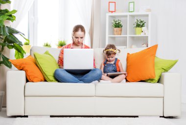 mother and child with computer and tablet at home, according to  clipart