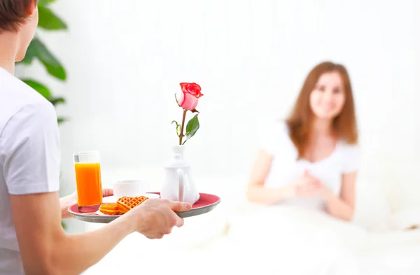 Man prepares breakfast in bed to beloved on Valentine's Day — Stock Photo, Image