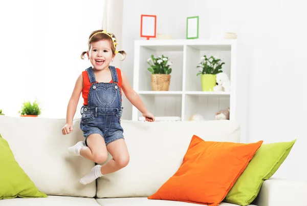 Oynama ve evde kanepede atlama kız mutlu çocuk — Stok fotoğraf
