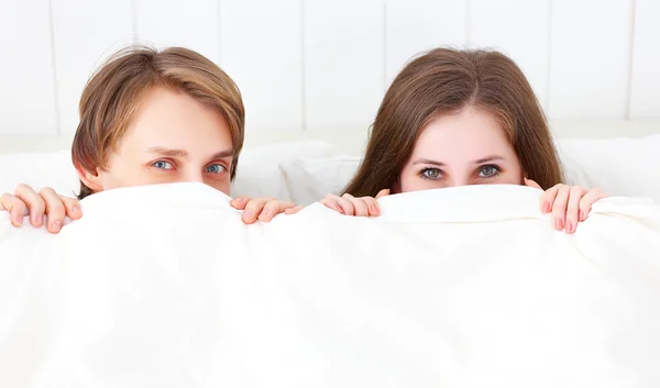 Feliz pareja riendo en la cama — Foto de Stock