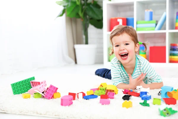 Fröhliches Kind lacht und spielt mit Spielzeughersteller — Stockfoto