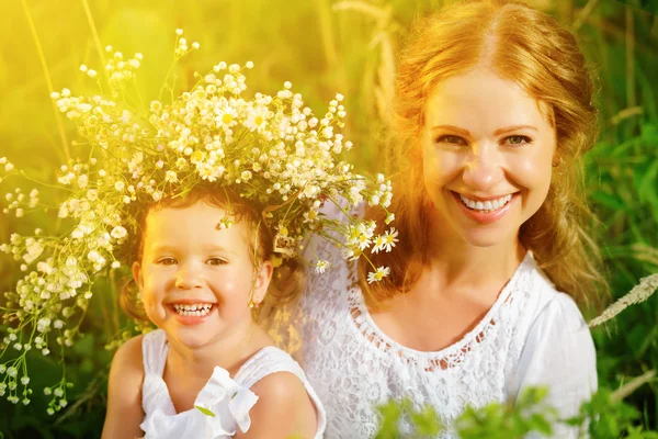 Happy laughing daughter hugging mother in wreaths of summer flow — Stock Photo, Image