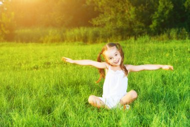 happy child little girl spread his arms in  white dress lying on clipart