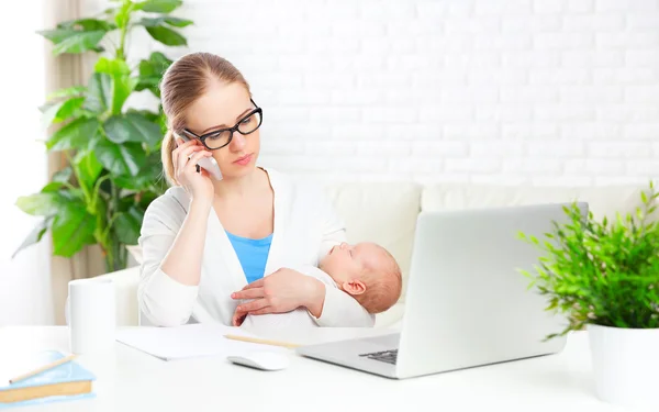 Business  mother works at home via Internet with newborn baby — Stock Photo, Image