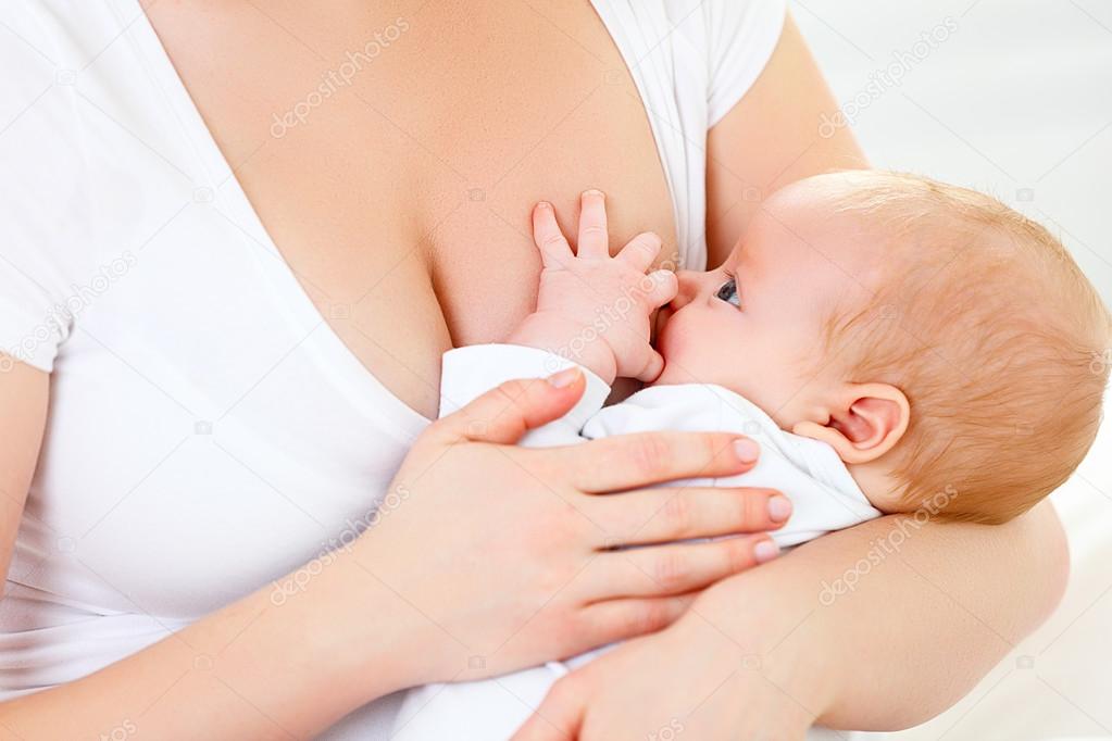 breastfeeding. mother holding newborn in embrace and breastfeed