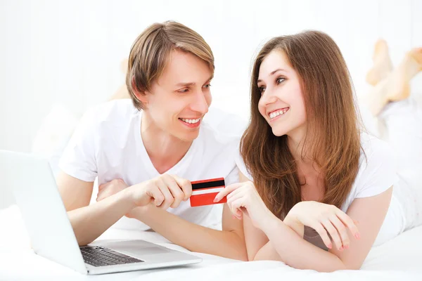 Щаслива пара робить інтернет-покупки з ноутбуком і кредитною карткою — стокове фото