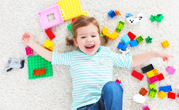 Fröhliches Kind lacht und spielt mit Spielzeughersteller — Stockfoto