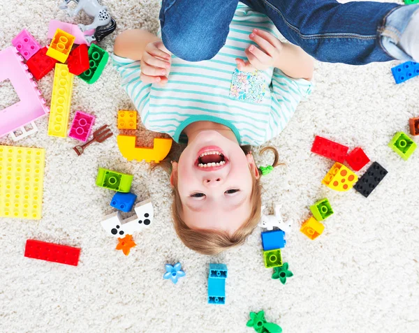 Fröhliches Kind lacht und spielt mit Spielzeughersteller — Stockfoto