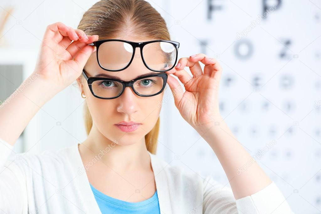 eyesight check. woman choose glasses at doctor ophthalmologist o