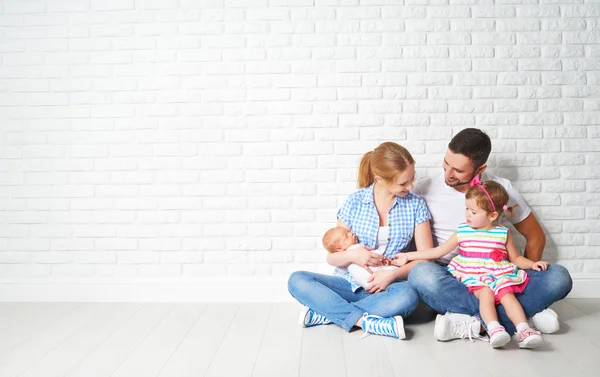 Feliz familia padre madre e hijos en la pared vacía —  Fotos de Stock