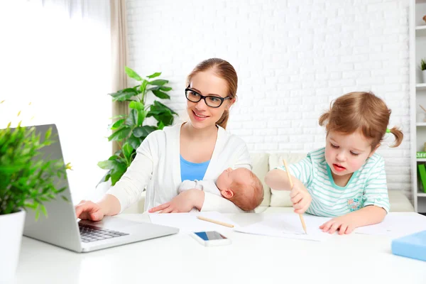 Business  mother works at home via the Internet with their child — Stock Photo, Image