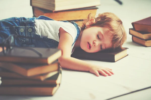 Tired little girl fell asleep for books — Stock Photo, Image