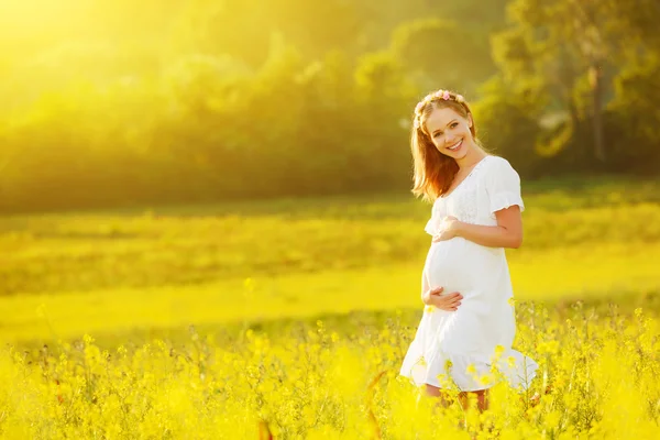 Hermosa mujer embarazada en verano naturaleza pradera con flo amarillo —  Fotos de Stock